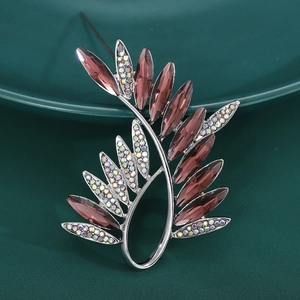 Elegant silver olive branch brooch with lavender crystals and rhinestones on dark ceramic
