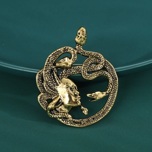 Détail d'une broche Méduse vintage dorée avec motif de serpent de la mythologie grecque