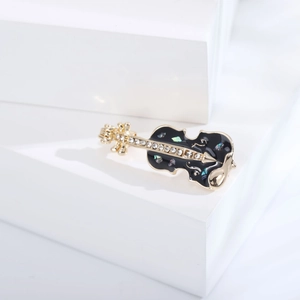 Élégante broche violon dorée avec émail noir, strass et incrustations en nacre irisées