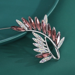 Macro detail of silver olive branch brooch with pink marquise crystals and rhinestones