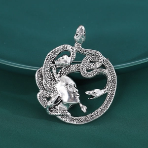 Vue détaillée de la broche Méduse en argent rétro avec textures d'écailles de serpent