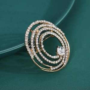 Détail d'une broche spirale dorée élégante avec micro-pavé de cristaux et un diamant central
