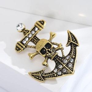 Detail of vintage gold anchor brooch with skull emblem and white sparkling rhinestones