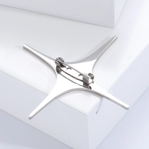 Detail view of the silver star brooch reverse side with a secure rotating pin clasp