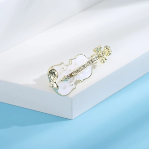 Vue détaillée d'une broche violon en émail avec bordure dorée et strass scintillants