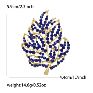 Macro detail of leaf brooch with blue rhinestones showing dimensions 5.9cm by 4.4cm
