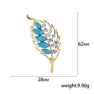 Elegant gold leaf brooch with turquoise stones and white rhinestones, dimensions 62mm by 28mm