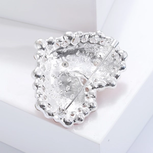 Close-up of heart-shaped brooch back with secure safety pin clasp and silver metal finish