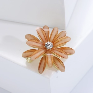 Elegant floral brooch with amber resin petals, gold finish and white diamond center
