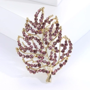 Macro shot of fashion leaf brooch with purple diamonds and golden metal base detail