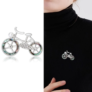 Elegant silver bicycle brooch with pearl and rhinestones shown on model and white backdrop