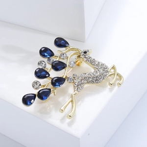 Détail de la broche cerf dorée sertie de diamants blancs et cristaux bleus en goutte