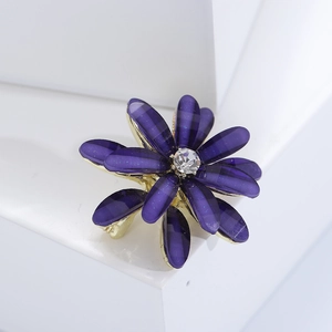 Macro view of purple flower brooch with sparkling petals and large central rhinestone