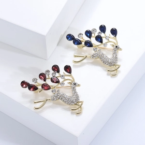 Détail de broches de cerf avec strass rouges et bleus en forme de larme sur base dorée