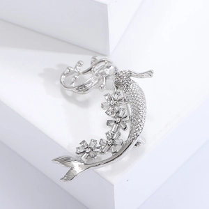 Dettaglio spilla sirena in argento con strass bianchi brillanti e accenti floreali