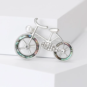 Detailed view of bicycle brooch with silver metal, sparkling crystals and white pearl