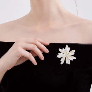 Elegant white daisy flower brooch with sparkling rhinestone on black velvet garment