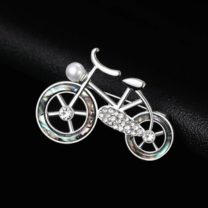 Macro detail of bicycle brooch featuring sparkling crystals and iridescent wheels
