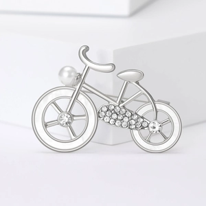Macro view of silver bicycle brooch with sparkling rhinestones and white pearl detail