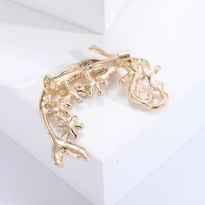 Dettaglio della spilla a sirena dorata in lega che mostra la chiusura in metallo sul retro