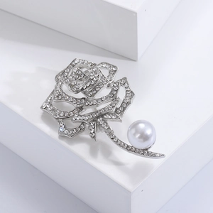 Detailaufnahme der handgefertigten Rosenbrosche mit glitzernden Kristallen und Perle