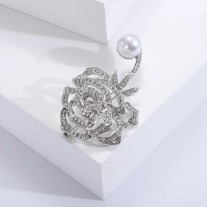 Makro-Detail der silbernen Rosenbrosche mit Pavé-Strass und weißem Perlen-Akzent