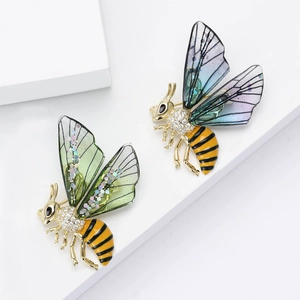 Elegante spilla ad ape in metallo dorato con zirconi e ali in acrilico verde e blu-viola