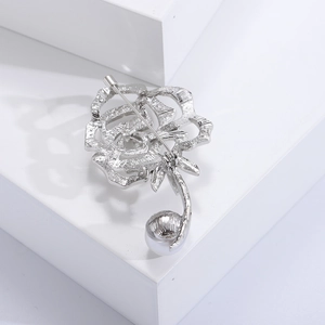 Detailansicht der Rückseite der silbernen Rosenbrosche mit Sicherheitsnadel und Metallstruktur