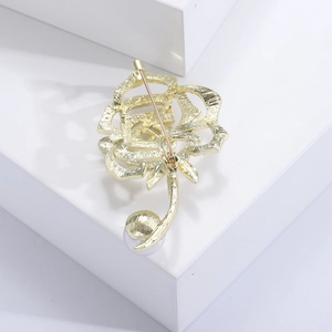 Detailansicht der Rückseite der goldenen Rosenbrosche mit weißer Perle auf Block