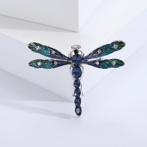 Macro detail of enamel dragonfly brooch with blue crystals and silver-plated alloy wings