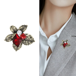 Vintage crystal flower brooch with red gems and pearl shown on model and white background