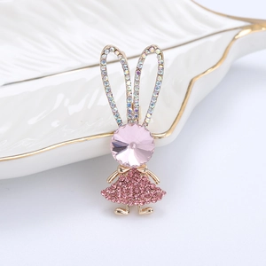 Dettaglio macro di spilla a coniglio rosa con gemma sfaccettata e strass scintillanti
