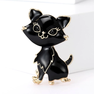 Detailed view of black enamel cat brooch with gold trim and sparkling black gemstone eyes