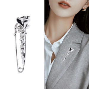 Silver rose brooch pin for women in vintage style on a gray blazer and white background