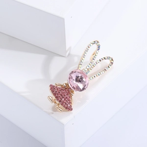 Spilla a coniglio rosa con cristalli e finitura dorata su supporto geometrico bianco