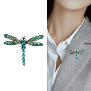 Elegant enamel dragonfly brooch with green rhinestones shown on white background and model