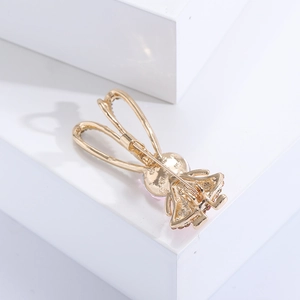 Dettaglio della spilla a coniglio dorata con chiusura stabile e cristalli rosa brillanti