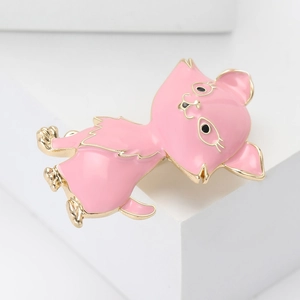 Detailed close-up of a pink enamel cat brooch with gold metal plating and cute animal design