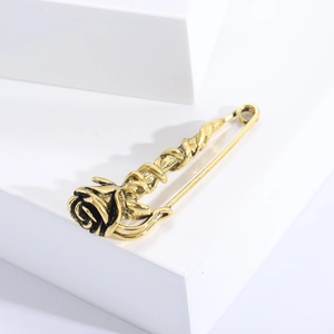 Detail of vintage gold rose brooch with intricate texture on white geometric block