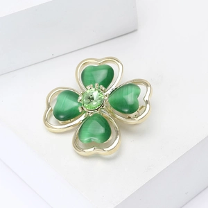 Elegant four-leaf clover brooch with green cat-eye stones and crystals in gold setting