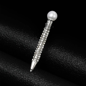 Detailed view of creative pen-shaped brooch with inlaid rhinestones and a large round pearl
