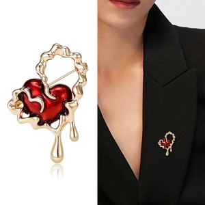 Elegant red enamel heart brooch with liquid gold metal frame shown on suit lapel