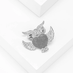 Silver alloy owl brooch with abalone shell details and heart wings on a white stand