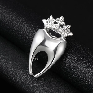 Macro d'une broche dent à couronne argentée avec strass sur cuir noir texturé