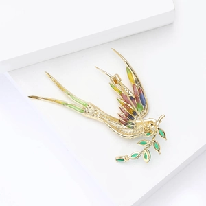 Detailed back view of a gold swallow brooch with olive branch and secure pin closure