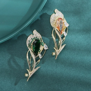 Broches tulipes dorées élégantes avec pierres émeraude et ambre sur velours vert