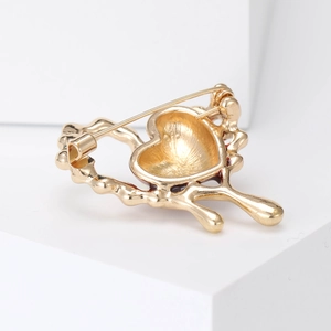 Elegant gold molten heart brooch with wavy dripping oil design on white display stand