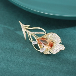 Vue macro d'une broche tulipe dorée avec pierre précieuse ambre et détails en zircon