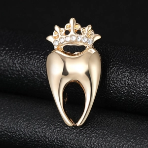 Gros plan d'une broche dentaire dorée avec couronne et strass sur cuir noir