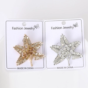 Detailed view of gold and silver starburst brooches set with sparkling crystals